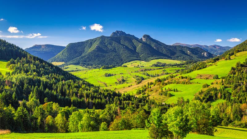 Hornatá krajina so skalnatými vrcholmi na pozadí pri slnečnom