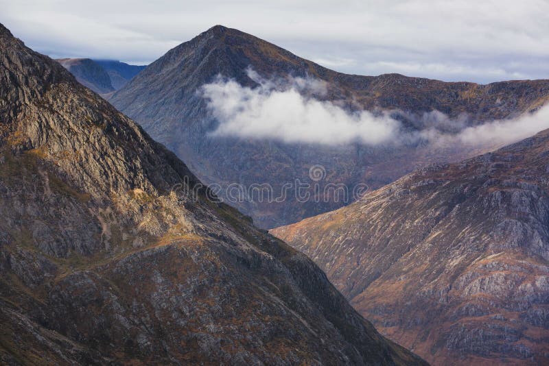 Mountains with clouds passing between stock image