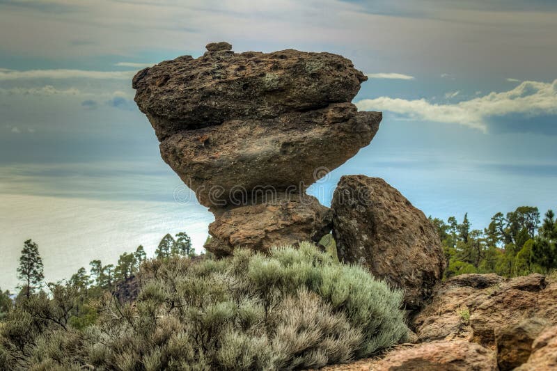 Mountains near Teide National Park. Old pine forest. The game of nature. A huge volcanic boulder on a small stone seems to be royalty free stock photo Mountains near Teide National Park. Old pine forest. The game of nature. A huge volcanic boulder on a small stone seems to be royalty free stock photo
