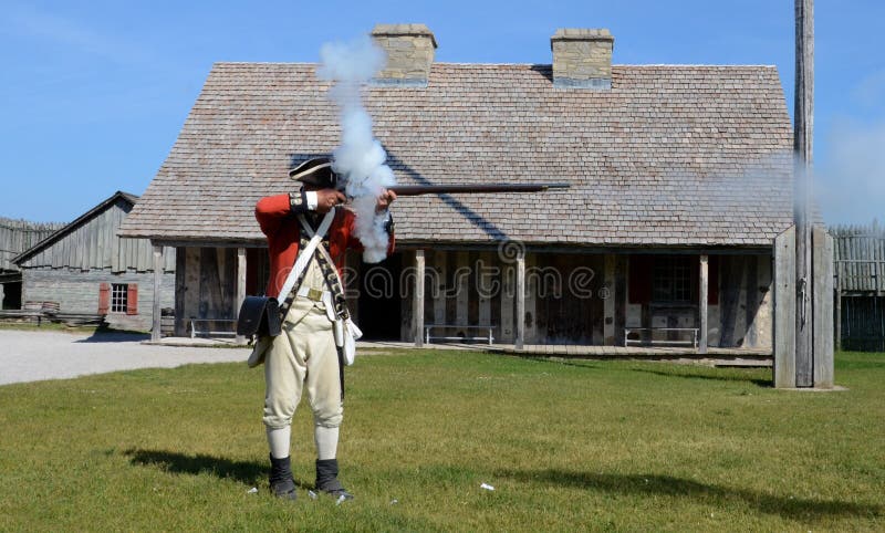 Mousquet re-enactor des feux au fort Michilimackinac photographie stock libre de droits Mousquet re-enactor des feux au fort Michilimackinac photographie stock libre de droits