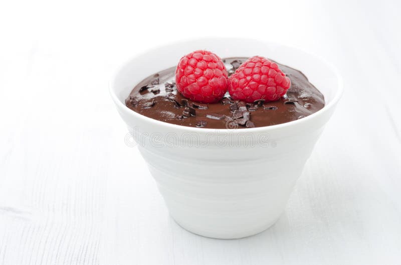 Mousse de chocolate con las frambuesas en un fondo blanco fotografía de archivo Mousse de chocolate con las frambuesas en un fondo blanco fotografía de archivo