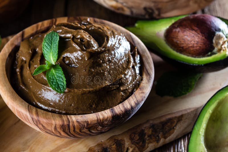 Mousse de chocolate del aguacate en cuenco de madera verde oliva foto de archivo libre de regalías Mousse de chocolate del aguacate en cuenco de madera verde oliva foto de archivo libre de regalías