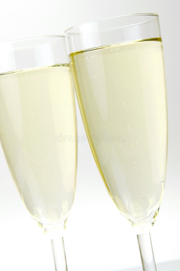 Flutes of sparkling wine isolated against a white background. Flutes of sparkling wine isolated against a white background