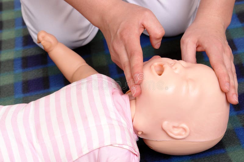 Dětská figurína první pomoc demonstrace série První pomoci instruktor ukazuje, jak umístit dítě hlavy dříve, než se přistoupí k úst do úst resuscitace.