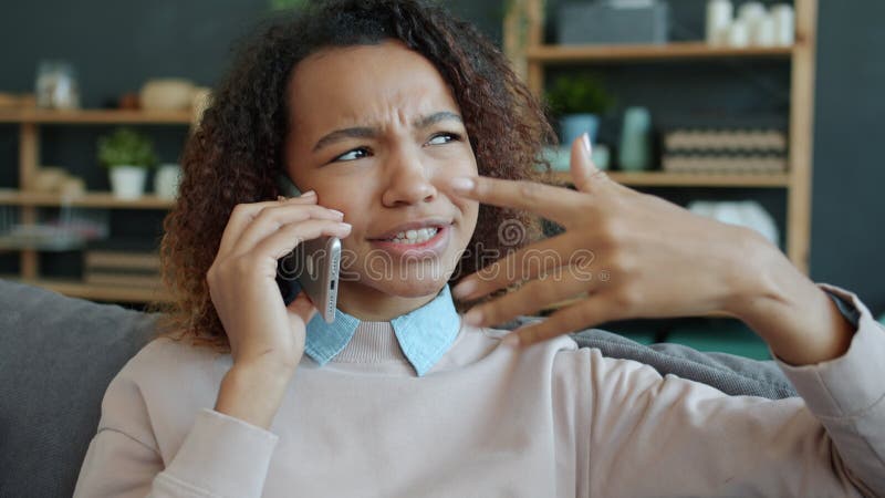 Mouvement lent de la femme heureuse afro-américaine à propos du téléphone portable et souriant à la maison clips vidéos