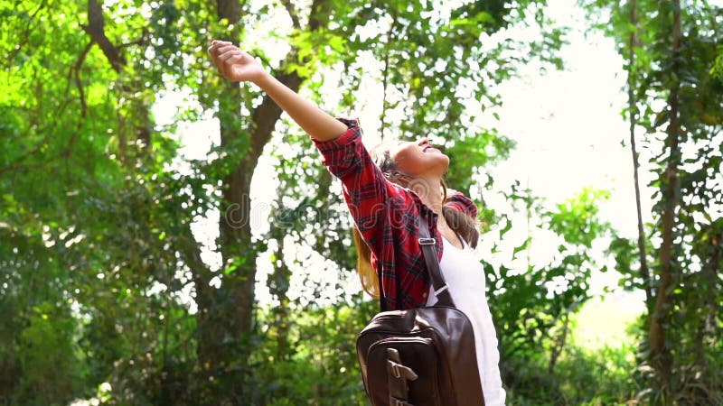 Mouvement lent - jeune voyageur asiatique heureux de femme avec le sac à dos marchant dans la forêt