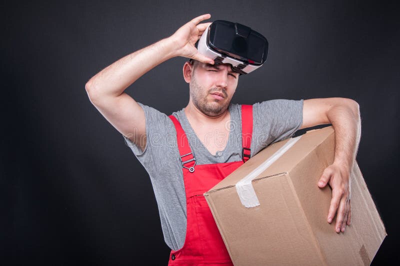Mover guy holding box and vr glasses over his eyes stock images