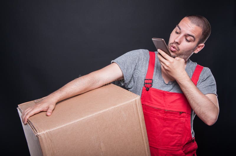Mover man holding box taking photo with smartphone stock images