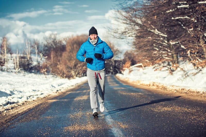 Movimentar-se muscular do homem do atleta exterior na neve, treinando imagens de stock royalty free Movimentar-se muscular do homem do atleta exterior na neve, treinando imagens de stock royalty free