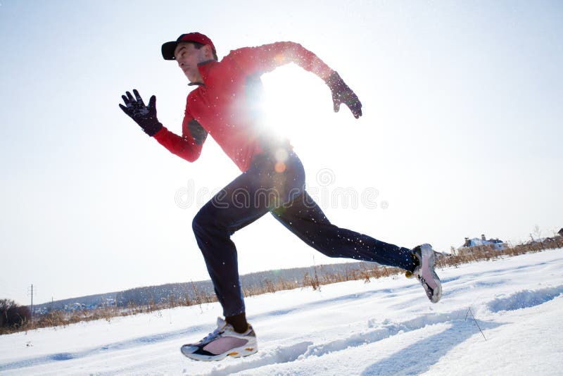 Athletic man running in winter day on snow. Athletic man running in winter day on snow