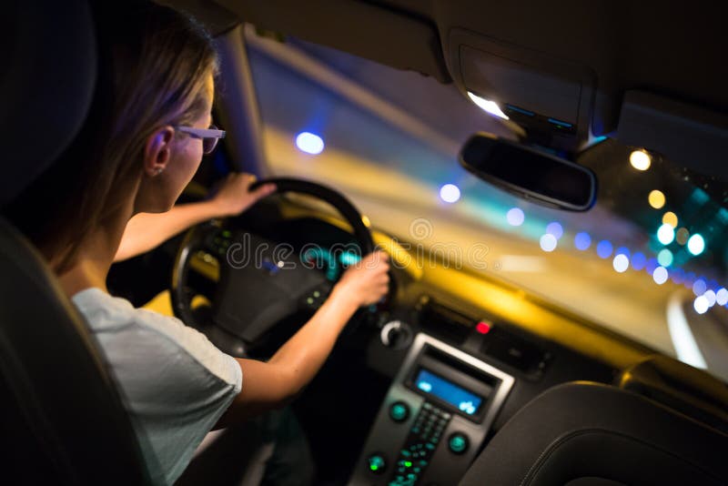 Movimentação fêmea que conduz um carro na noite