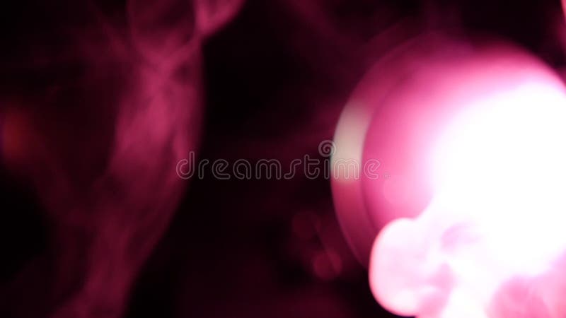 Movimento do fumo branco com iluminação roxa, no preto