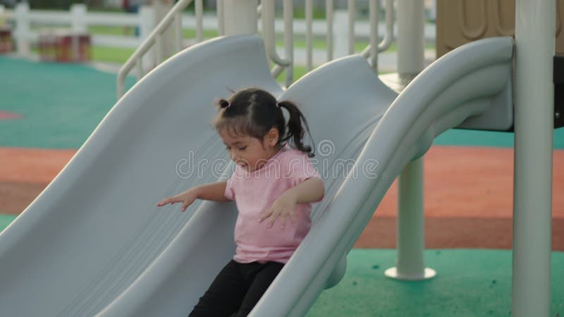 Movimiento lento de la bebé que se desliza y juega en el patio metrajes