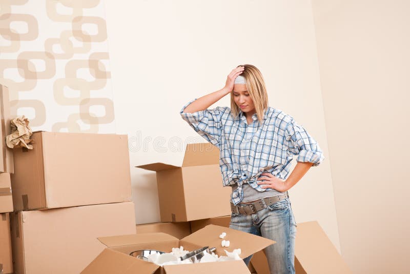 Moving house: Young woman unpacking box