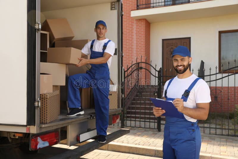 Moving Service Workers Outdoors, Unloading Boxes and Checking List ...