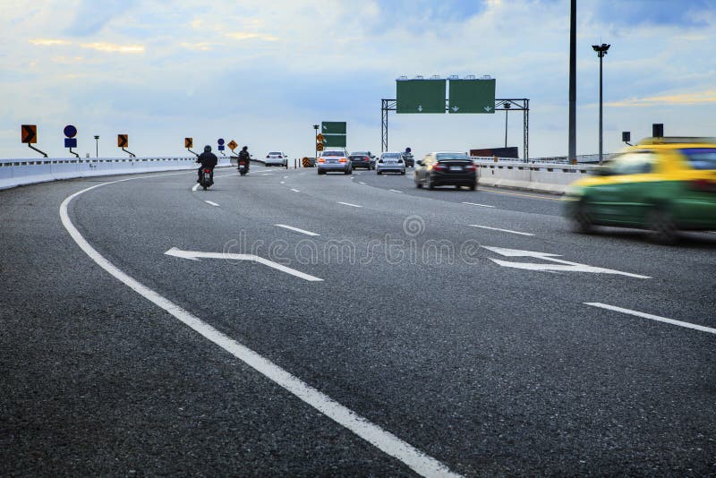 Moving пассажирский автомобиль и мотоцикл на junct пути моста пересекая стоковые фотографии rf Moving пассажирский автомобиль и мотоцикл на junct пути моста пересекая стоковые фотографии rf