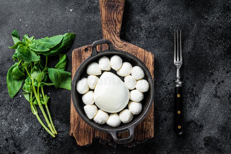 Mozzarella Cheese Mini Balls in Pan with Basil. Black Background Stock