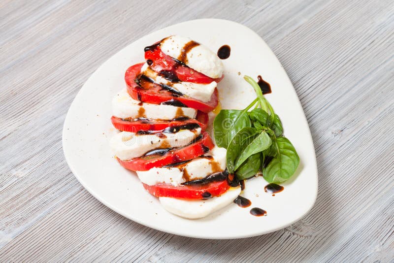 Mozzarella cheese and tomato with basil twig