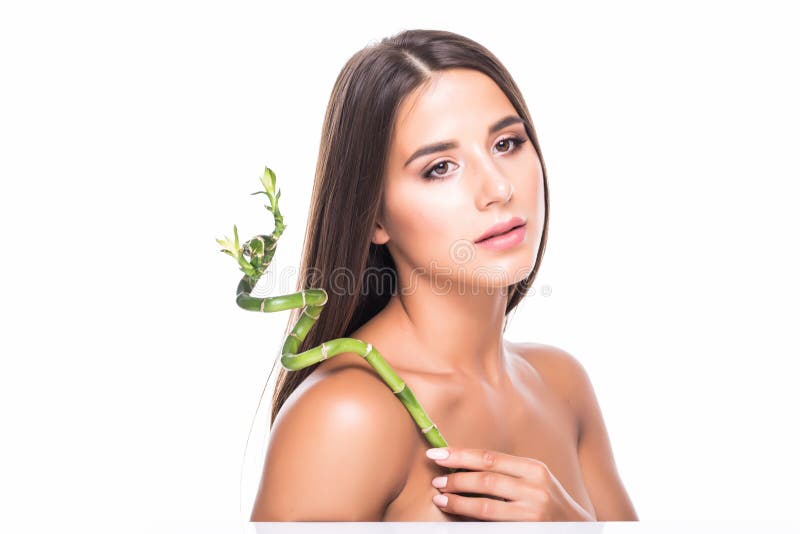 A moça bonita no estúdio em um fundo branco guarda uma folha tropical verde nas mãos e cobre uma parte de sua cara fotografia de stock A moça bonita no estúdio em um fundo branco guarda uma folha tropical verde nas mãos e cobre uma parte de sua cara fotografia de stock