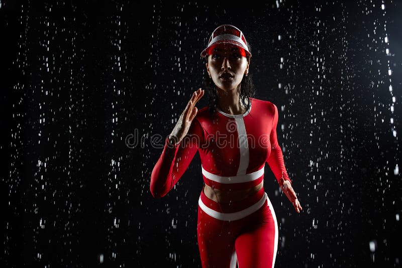 Moça bonita no sportswear que corre no estúdio do aqua Gotas da água espalhadas sobre seu corpo da aptidão fotografia de stock royalty free Moça bonita no sportswear que corre no estúdio do aqua Gotas da água espalhadas sobre seu corpo da aptidão fotografia de stock royalty free