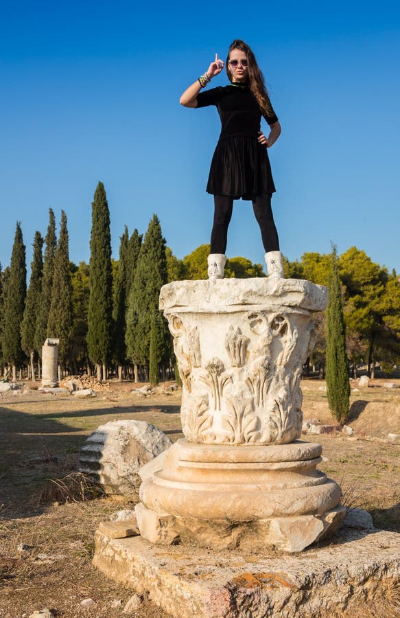 Moça grega bonita que guarda uma embarcação antiga no teatro antigo da ilha de Thassos, Grécia imagem de stock Moça grega bonita que guarda uma embarcação antiga no teatro antigo da ilha de Thassos, Grécia imagem de stock