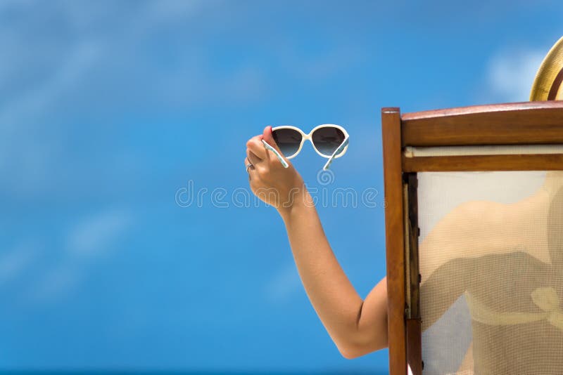 Moça que encontra-se em um vadio da praia com vidros à disposição na ilha tropical