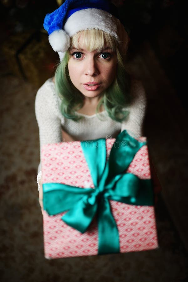 A moça 'sexy' dá o presente sob a árvore de Natal imagem de stock A moça 'sexy' dá o presente sob a árvore de Natal imagem de stock