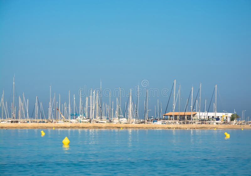 CAN PASTILLA, MAJORCA, BALEARIC ISLANDS, SPAIN - JULY 24, 2013: Morning in Cala Estancia with yellow buoys on tranquil water on a sunny summer morning on July 24, 2013 in Can Pastilla, Balearic islands, Spain. CAN PASTILLA, MAJORCA, BALEARIC ISLANDS, SPAIN - JULY 24, 2013: Morning in Cala Estancia with yellow buoys on tranquil water on a sunny summer morning on July 24, 2013 in Can Pastilla, Balearic islands, Spain.