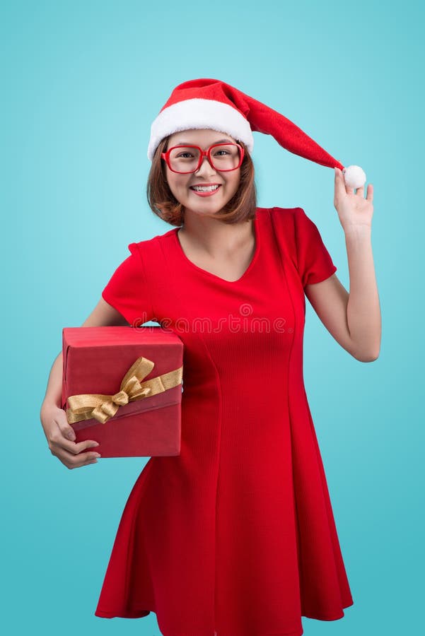 Mrs. Santa. Beautiful young asian woman in santa`s hat holding a royalty free stock images Mrs. Santa. Beautiful young asian woman in santa`s hat holding a royalty free stock images