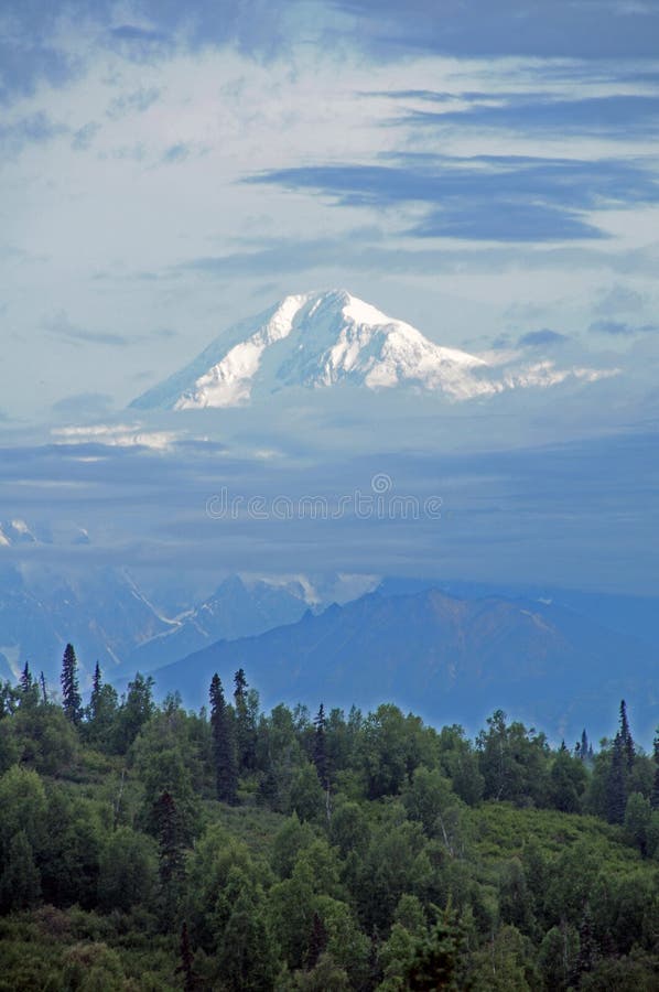 Mt. McKinley rises out of the early morning mist. Mt. McKinley, known as Denaii to native Alaskans, rises out of the clouds on a misty August 2015 morning. It is stock images Mt. McKinley rises out of the early morning mist. Mt. McKinley, known as Denaii to native Alaskans, rises out of the clouds on a misty August 2015 morning. It is stock images