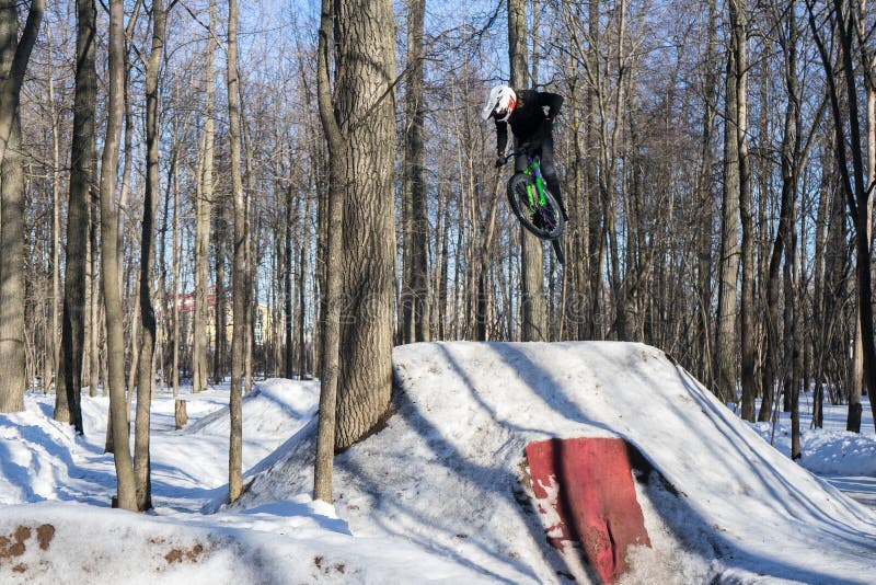 Mtb rider does trick on dirt jumping in winter. Cyclist doing springboard stunt
