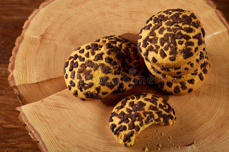 Mucchio dei biscotti su un ceppo di legno rotondo sopra fondo di legno rustico, primo piano, fuoco selettivo fotografie stock Mucchio dei biscotti su un ceppo di legno rotondo sopra fondo di legno rustico, primo piano, fuoco selettivo fotografie stock