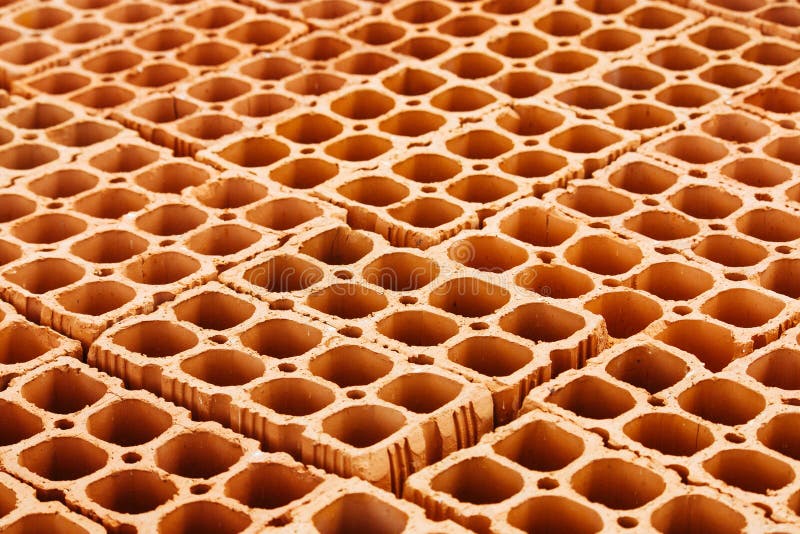 Mucchio dei mattoni vuoti rossi con i grandi fori che formano un modello geometrico di ripetizione fotografia stock Mucchio dei mattoni vuoti rossi con i grandi fori che formano un modello geometrico di ripetizione fotografia stock