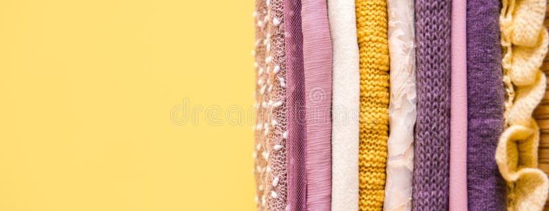 Mucchio dei vestiti sulla tavola porpora porpora e rosa gialli immagini stock Mucchio dei vestiti sulla tavola porpora porpora e rosa gialli immagini stock