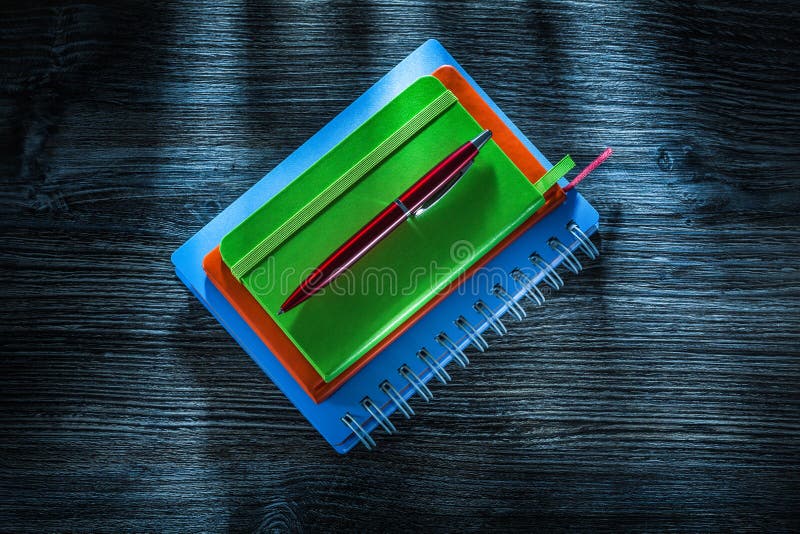 Mucchio della penna dei taccuini sul bordo di legno d'annata fotografia stock libera da diritti Mucchio della penna dei taccuini sul bordo di legno d'annata fotografia stock libera da diritti