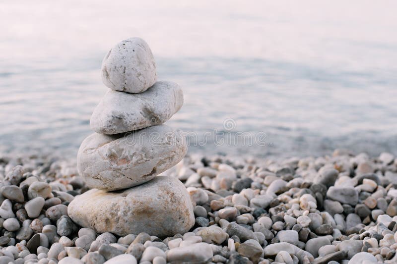 Mucchio delle pietre del ciottolo sopra il mare blu nei precedenti immagini stock libere da diritti Mucchio delle pietre del ciottolo sopra il mare blu nei precedenti immagini stock libere da diritti