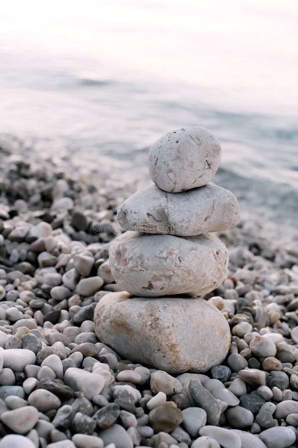 Mucchio delle pietre del ciottolo sopra il mare blu nei precedenti fotografie stock libere da diritti Mucchio delle pietre del ciottolo sopra il mare blu nei precedenti fotografie stock libere da diritti