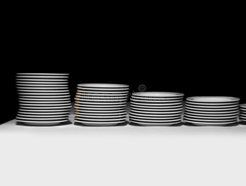 Pile of white plates on a black background. Pile of white plates on a black background