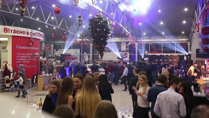Mucha gente en el partido corporativo del ` s del Año Nuevo con la ejecución del árbol de navidad en techo en el movimiento rápid almacen de video Mucha gente en el partido corporativo del ` s del Año Nuevo con la ejecución del árbol de navidad en techo en el movimiento rápid almacen de video