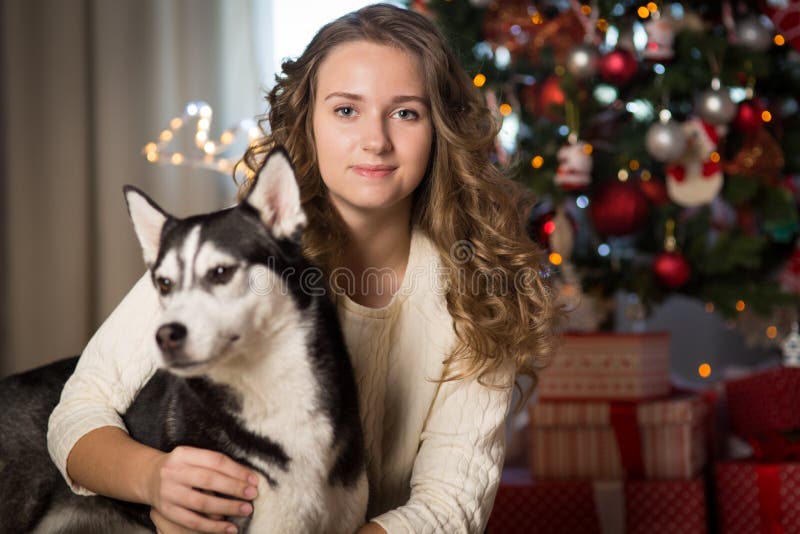 Muchacha adolescente con el perro, para la Navidad fotografía de archivo libre de regalías Muchacha adolescente con el perro, para la Navidad fotografía de archivo libre de regalías