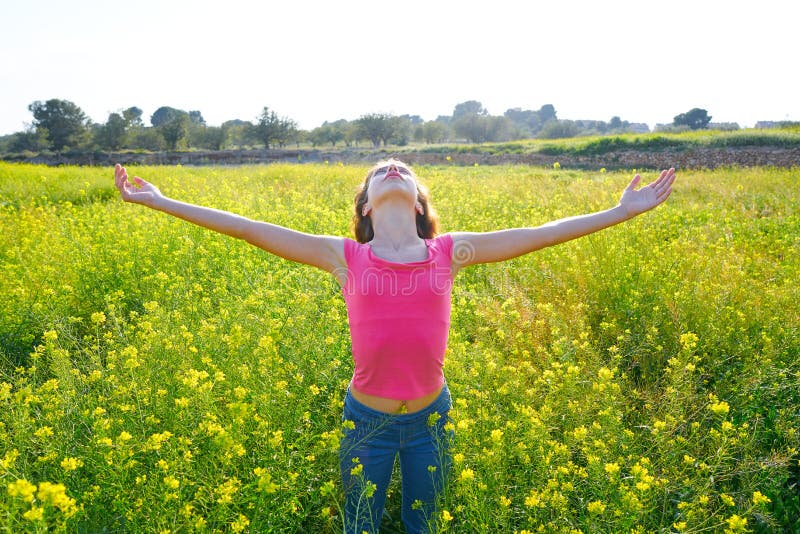 Muchacha adolescente feliz de los brazos abiertos en prado de la primavera fotografía de archivo Muchacha adolescente feliz de los brazos abiertos en prado de la primavera fotografía de archivo