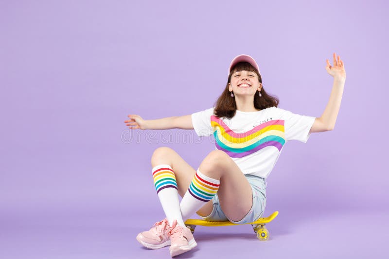 Muchacha adolescente sonriente alegre en la ropa viva que se sienta en el monopat?n amarillo, manos de extensi?n aisladas en el p fotos de archivo libres de regalías Muchacha adolescente sonriente alegre en la ropa viva que se sienta en el monopat?n amarillo, manos de extensi?n aisladas en el p fotos de archivo libres de regalías