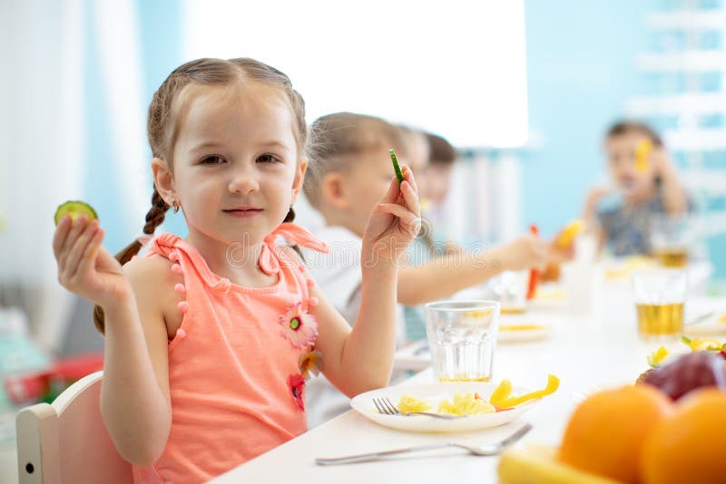 Muchacha adorable del niño que come verduras en guardería foto de archivo Muchacha adorable del niño que come verduras en guardería foto de archivo