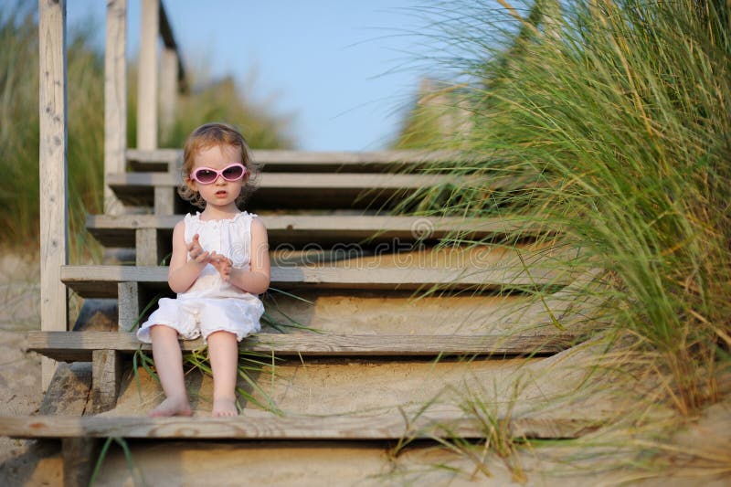 Muchacha adorable del niño que se sienta en las escaleras imagen de archivo libre de regalías Muchacha adorable del niño que se sienta en las escaleras imagen de archivo libre de regalías