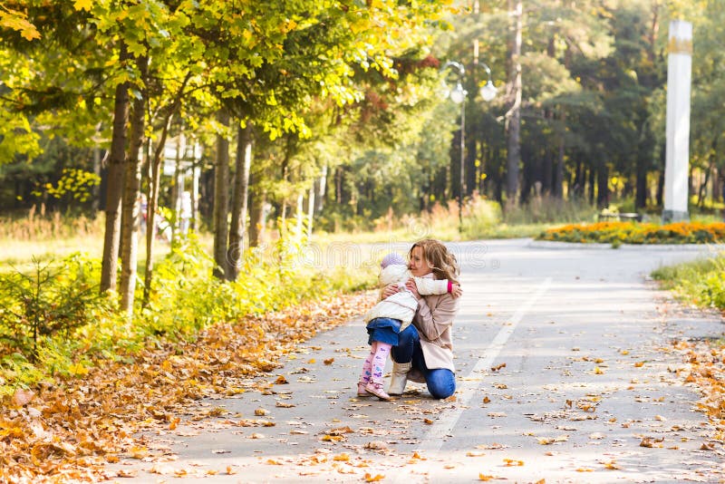 Muchacha adorable del niño y mujer joven en la hija hermosa del bosque del otoño que corre para mimar Retrato de la familia, caíd