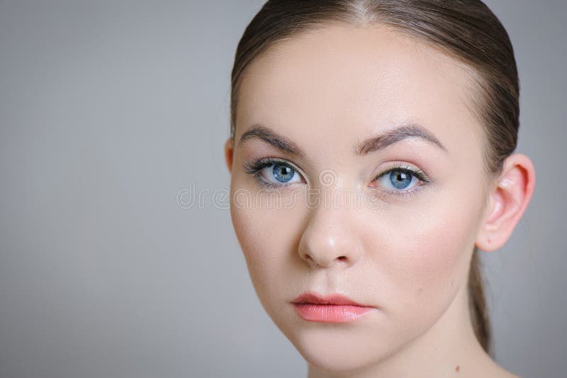 Muchacha adulta hermosa que presenta con maquillaje desnudo con la piel limpia y cuidar su piel imagenes de archivo Muchacha adulta hermosa que presenta con maquillaje desnudo con la piel limpia y cuidar su piel imagenes de archivo