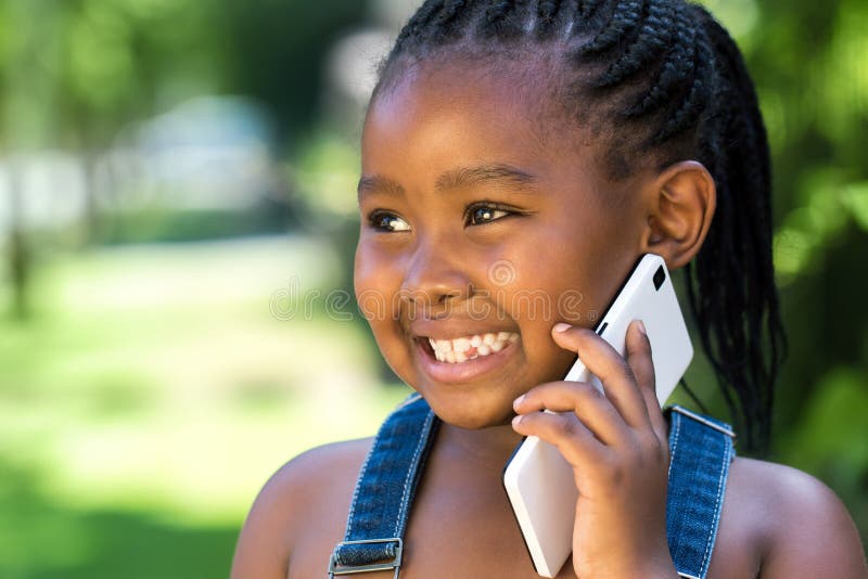 Close up outdoor portrait of cute little african girl having conversation on smart phone. Close up outdoor portrait of cute little african girl having conversation on smart phone.