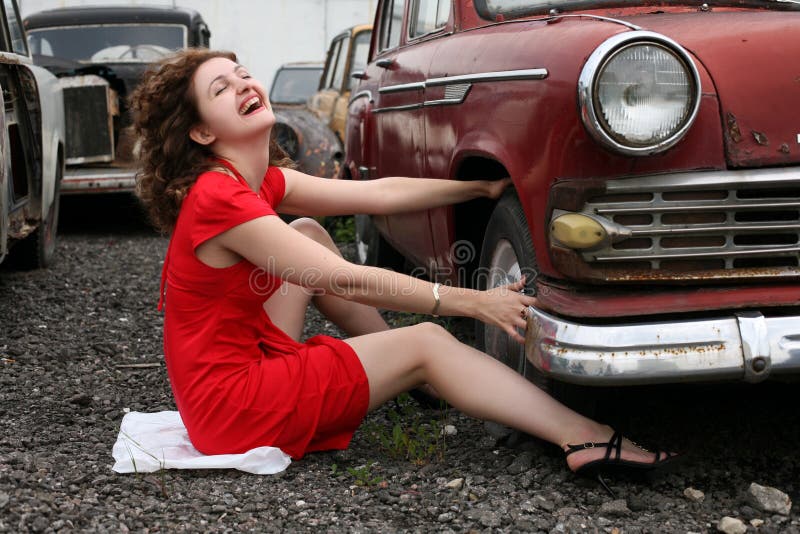 Girl beside retro car - under constructions to wheel. Girl beside retro car - under constructions to wheel