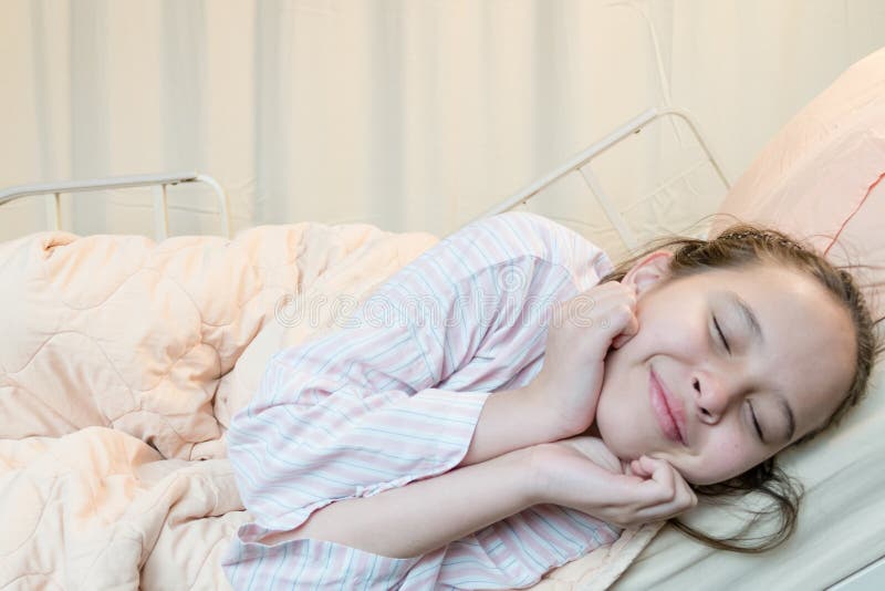 Muchacha alegre del tween de la raza mixta en cama de hospital imágenes de archivo libres de regalías