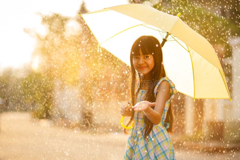 Muchacha asiática bastante joven en la lluvia imagen de archivo libre de regalías